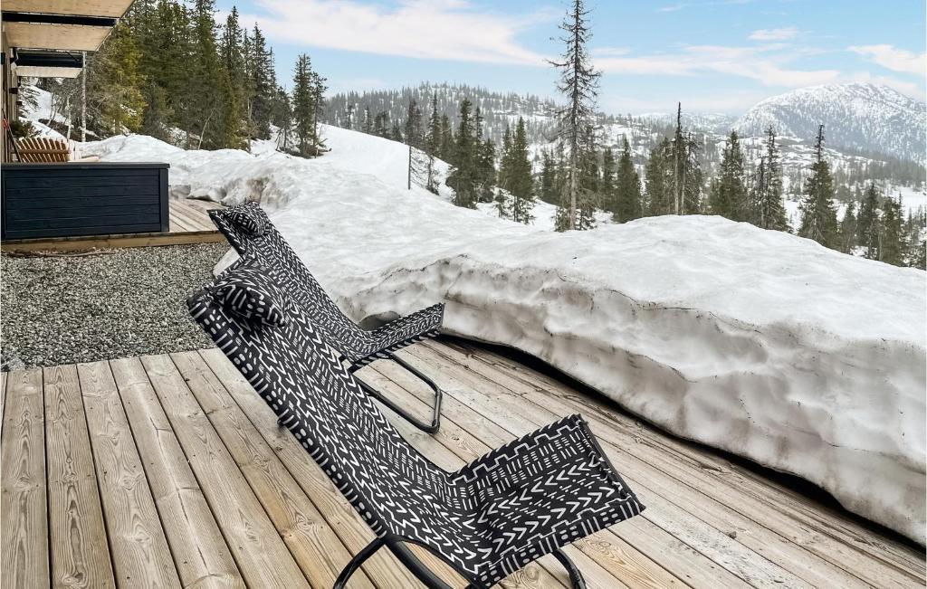 une banquette assise sur une terrasse en bois avec neige dans l'établissement Cozy Apartment In Fl With Kitchen, à Flå