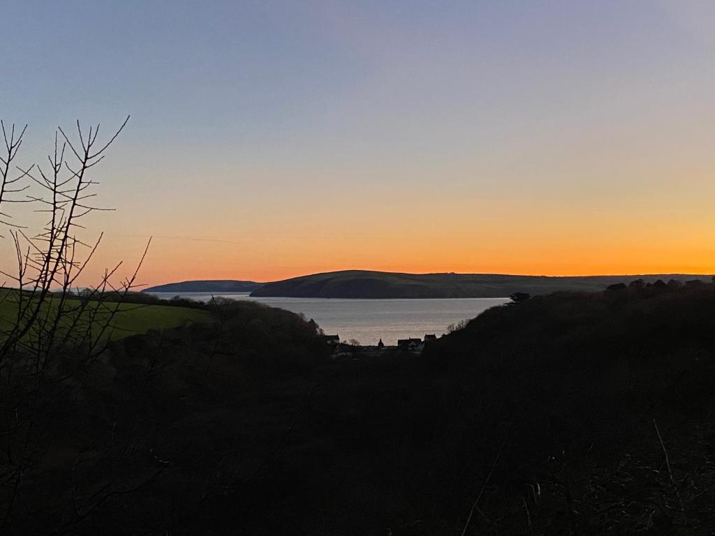 a sunset over a body of water at Ty Nain, Newport, Pembrokeshire in Newport Pembrokeshire