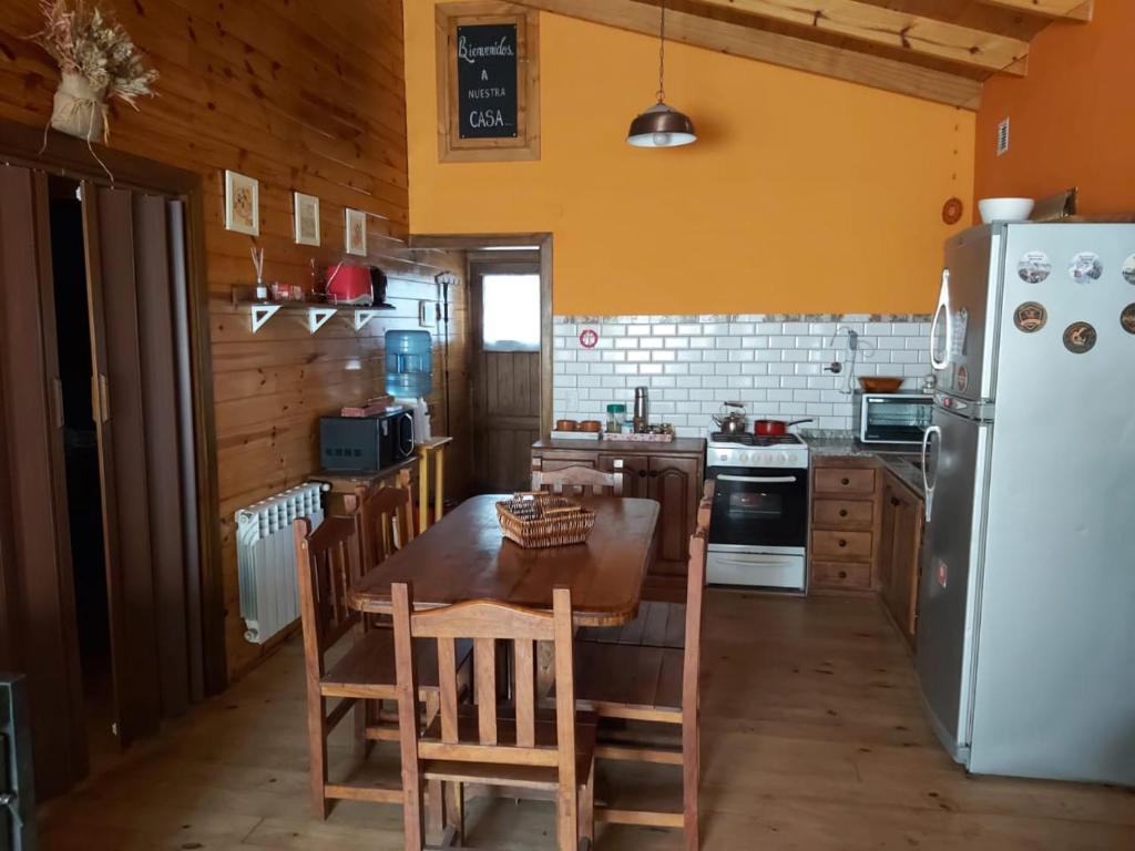 cocina con mesa y nevera blanca en La Peninsula Cabaña en San Carlos de Bariloche