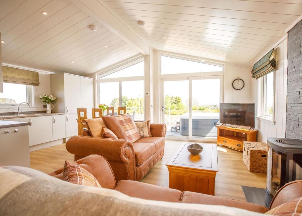 a living room with a couch and a table at Drumcarrow Luxury Lodges in St. Andrews