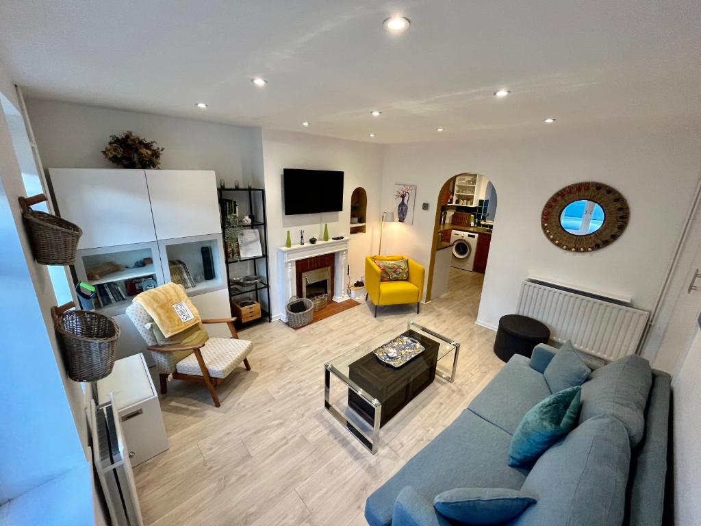 sala de estar con sofá azul y mesa en Entire 3 Bed House Weybridge Brooklands, London, en Byfleet