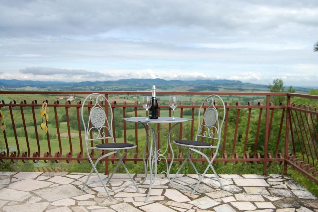 een tafel en 2 stoelen met een fles wijn bij Un angolo di Paradiso in Ozzano Monferrato