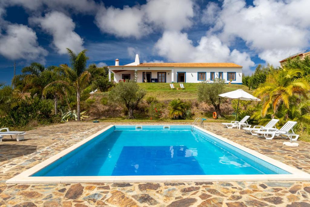 a villa with a swimming pool and a house at Monte Cerro da Vigia by Vacationy in Zambujeira do Mar