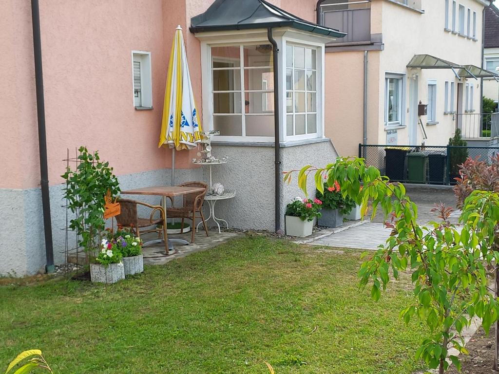 eine Terrasse mit einem Tisch und einem Sonnenschirm auf einem Haus in der Unterkunft Ferienwohnung Ravensburg in Ravensburg