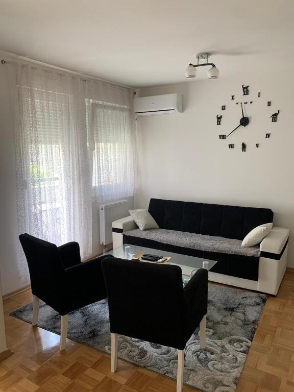 sala de estar con sofá y reloj en la pared en STAN U CENTRU PRIJEDORA IZDAVANJE en Prijedor
