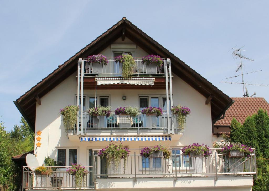 ein Gebäude mit Blumenkästen auf den Balkonen in der Unterkunft Ferienwohnungen Eva Lange in Uhldingen-Mühlhofen