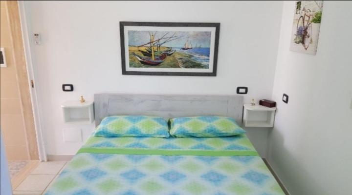 un letto in una camera da letto con una foto sul muro di Mareide a Torre Lapillo