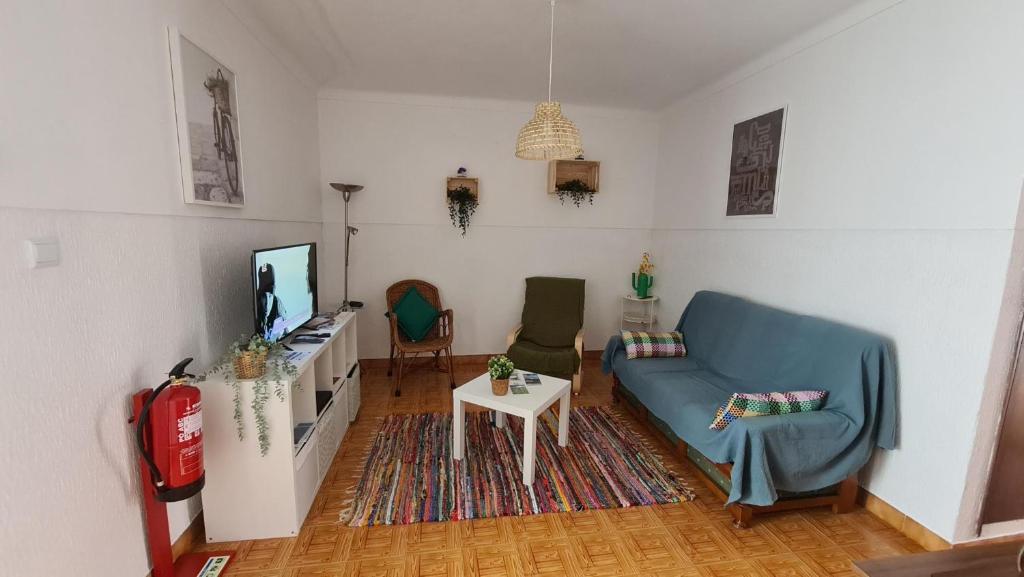 uma sala de estar com um sofá e uma televisão em Casa Castanheiro em Tolosa