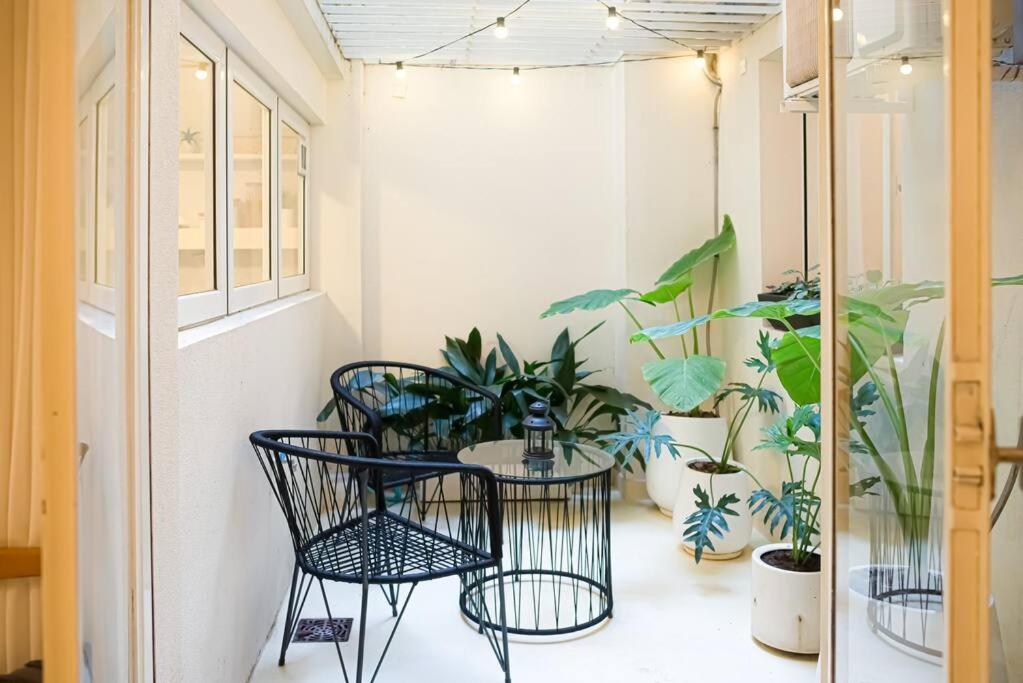 uma varanda com mesa, cadeiras e plantas em jh - Creado como un Hotel Boutique em Buenos Aires