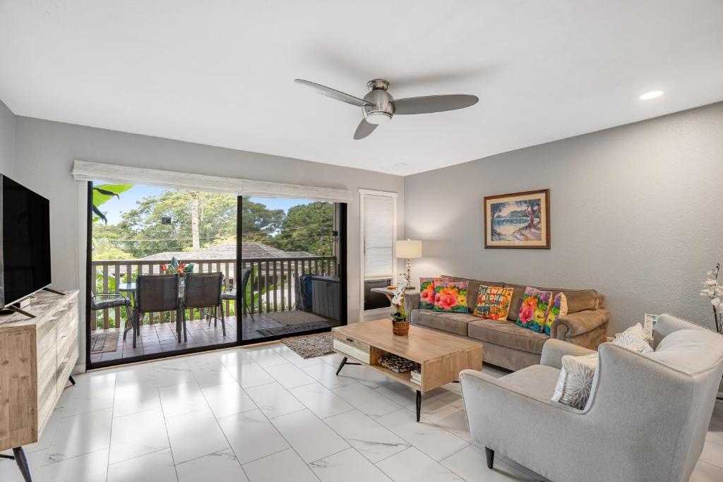 - un salon avec un canapé et une télévision dans l'établissement Waikomo Stream Villas 322, à Koloa