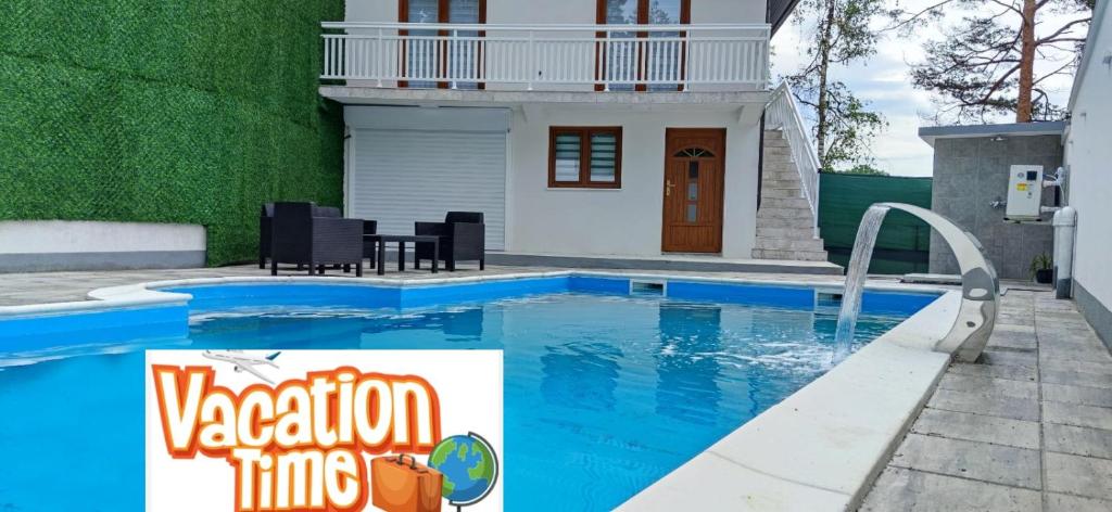 a swimming pool in front of a house at Top Holiday Kuca sa bazenom in Lukavac