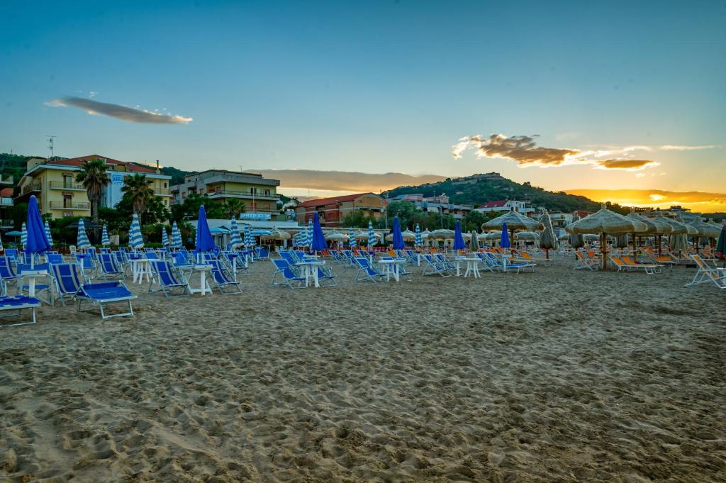 eine Gruppe von Stühlen und Sonnenschirmen am Strand in der Unterkunft Hotel Miramare - Silvi Marina in Silvi Marina