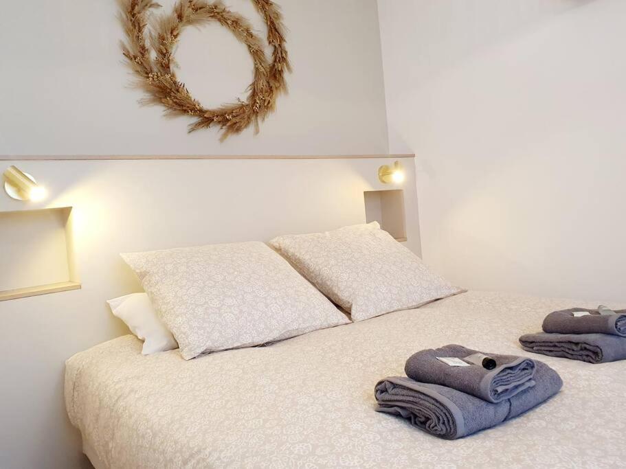 - une chambre avec un lit et des serviettes dans l'établissement L'Or Miroir - Madame Conciergerie, à Bruz