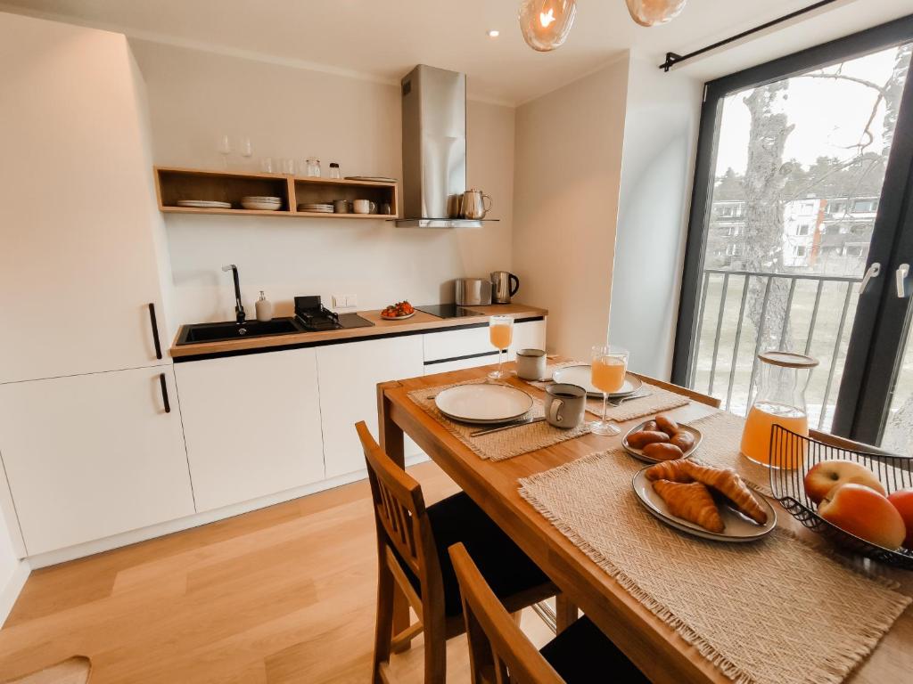 una cocina con una mesa de madera con comida. en Beautiful Seaside apartement Albatross 23, en Ķesterciems