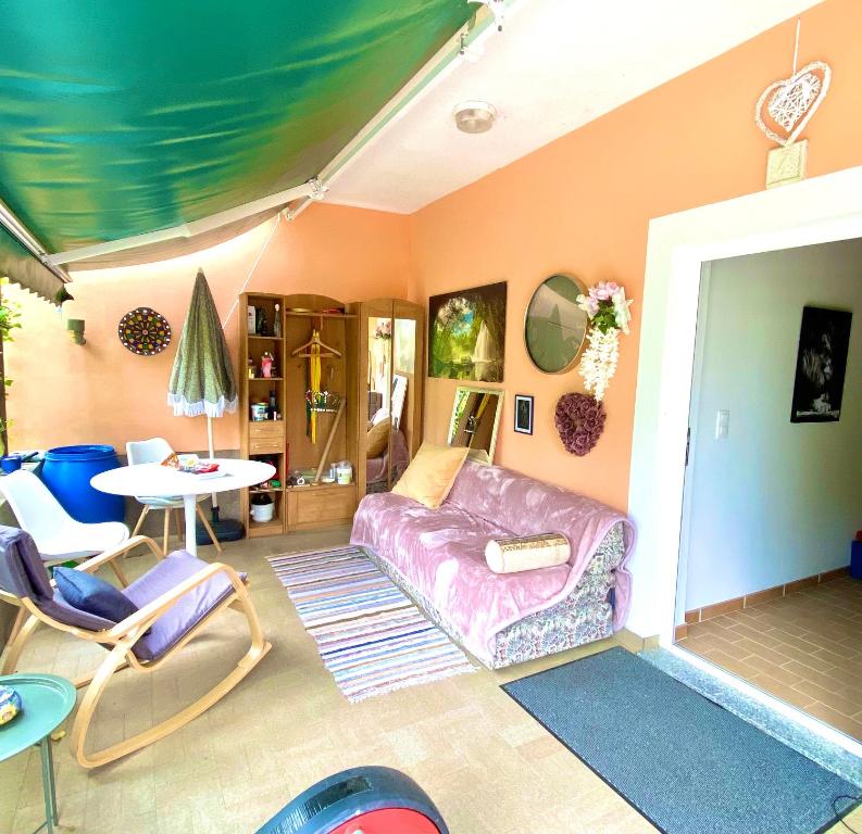 a living room with a purple couch and a table at Casa Erceg Amor vincit Omnia in Skradin