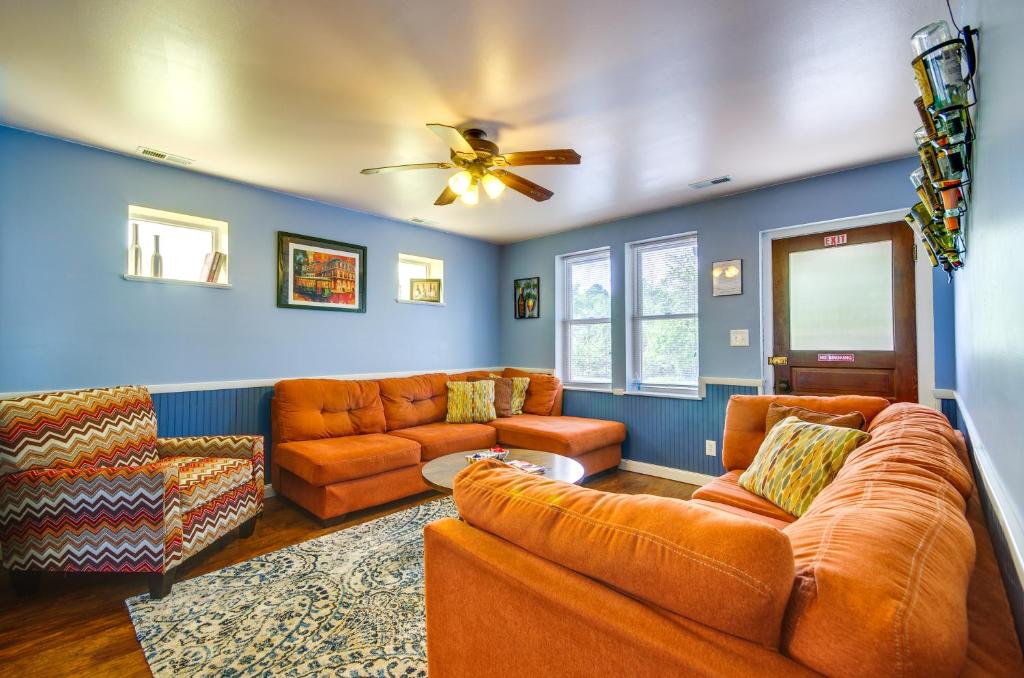 sala de estar con muebles de color naranja y ventilador de techo en Downtown Hermann Vacation Home Near Wineries!, en Hermann