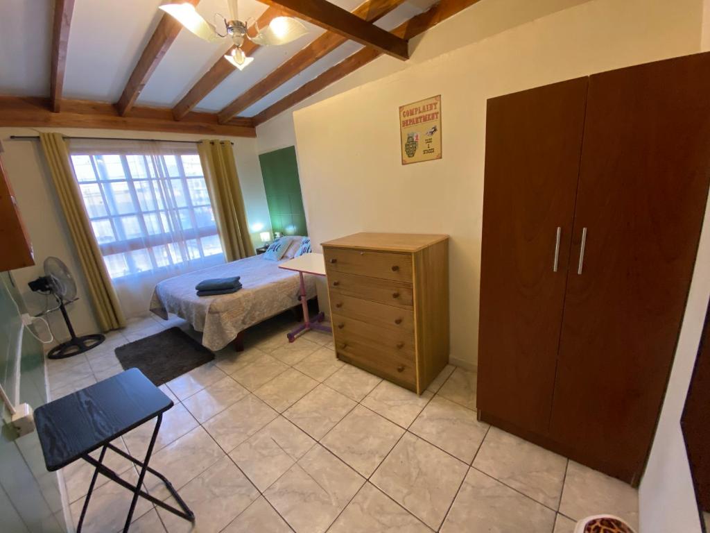 a room with a bedroom with a bed and a dresser at Habitaciones en pensión en centro de Iquique in Iquique