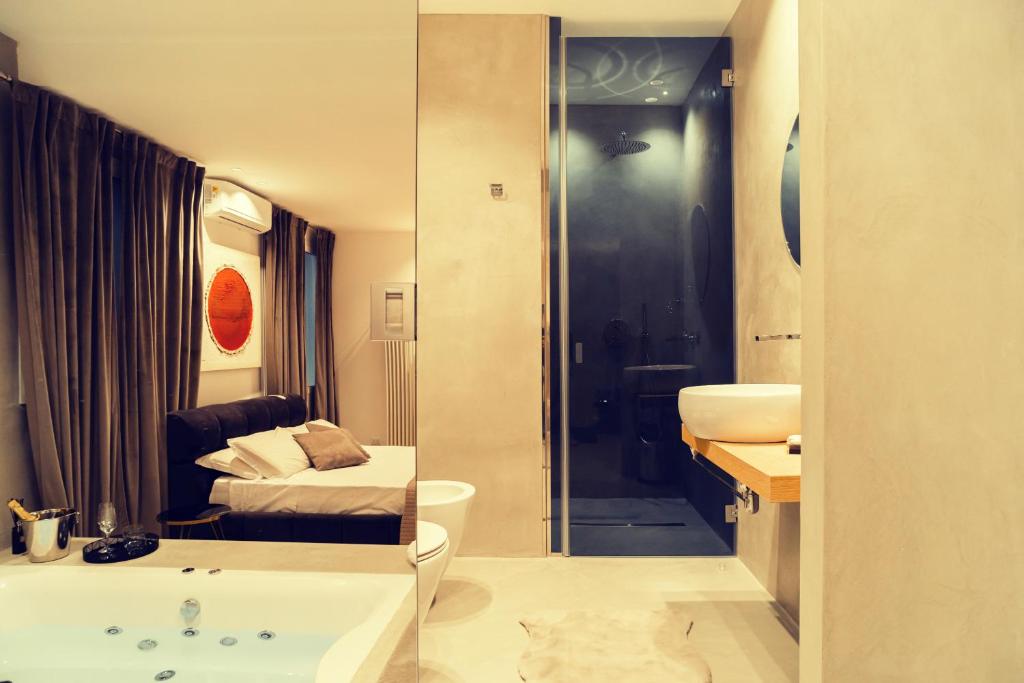 Four Luxury Suite في باليرمو: حمام مع سرير وحوض استحمام في الغرفة