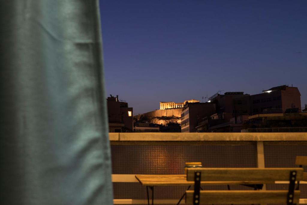 - Balcón con mesa y sillas y vistas al perfil urbano en Acropolis view apartment in Athens, en Atenas