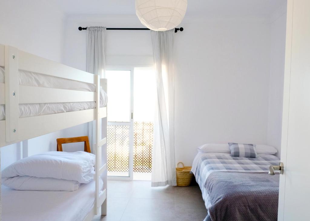 a bedroom with two bunk beds and a window at Lonja del Ribacillo, Casa Rural in Almodóvar del Río