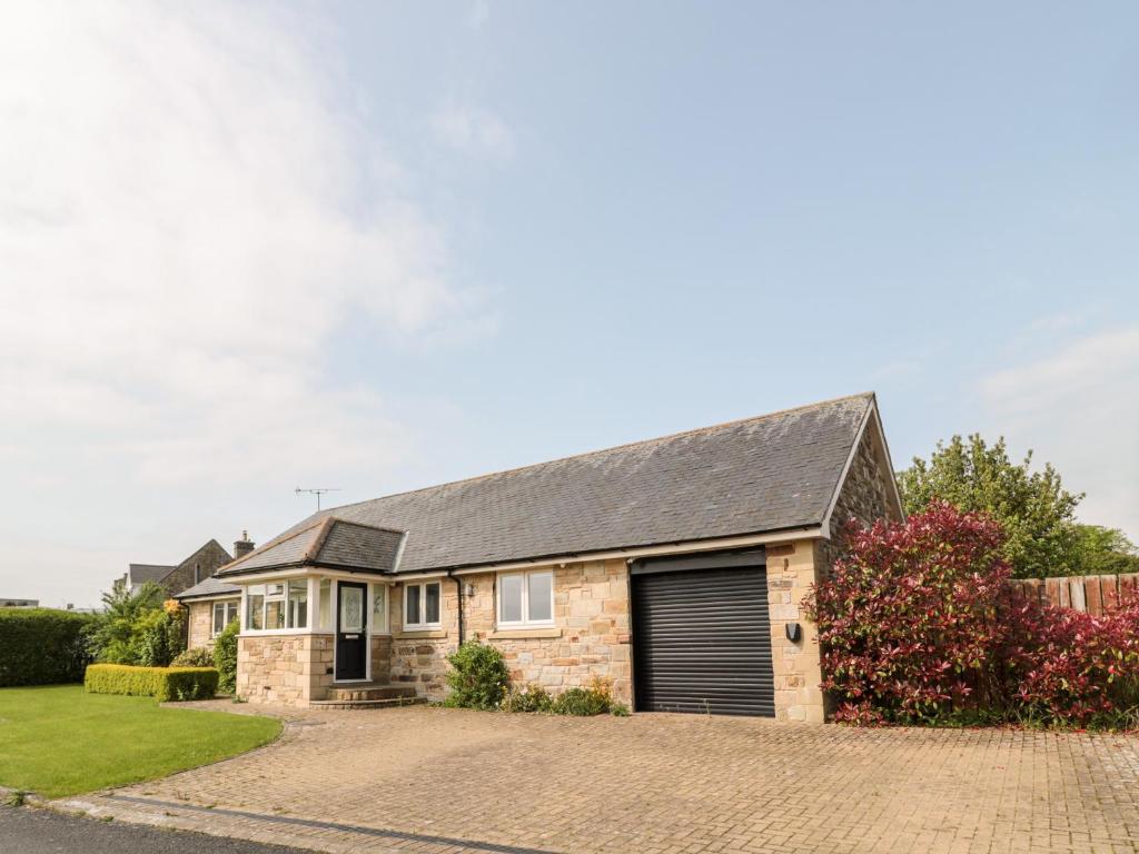 a brick house with a garage at The Croft in Alnwick