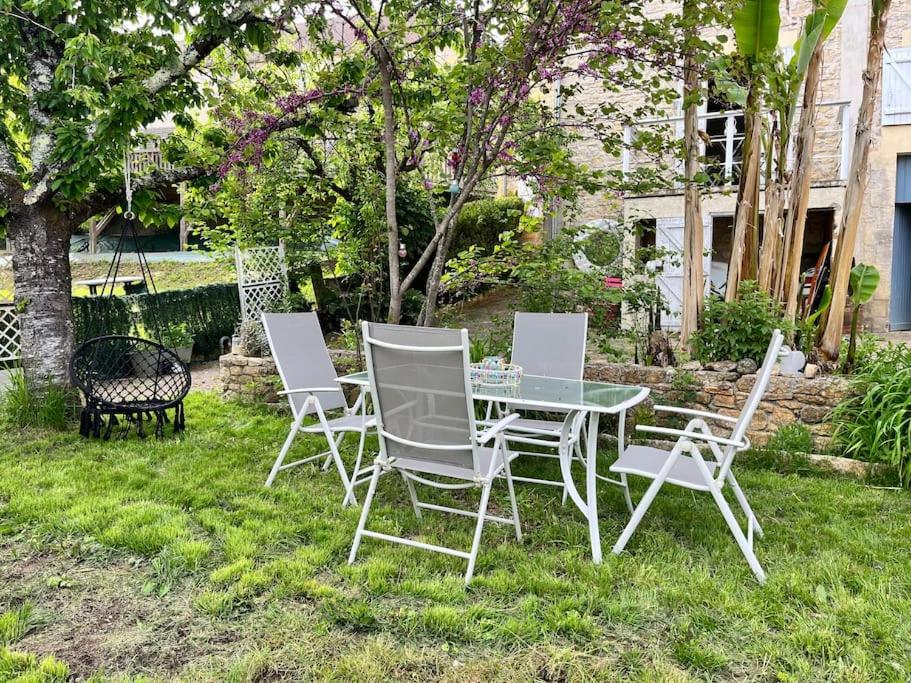 una mesa y sillas sentadas en el césped en Le Périgourdin, en Saint-Cyprien