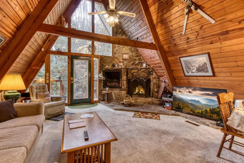 a living room with a fireplace in a log cabin at Mountain Springs Chalet in Gatlinburg