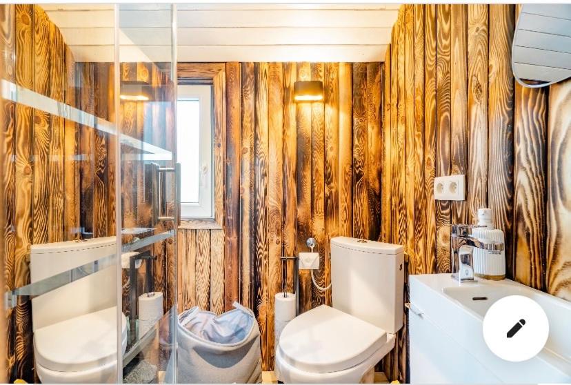 un bagno con un water e un lavandino di Roulotte du puits avec jacuzzi et sauna privatif a Havinnes
