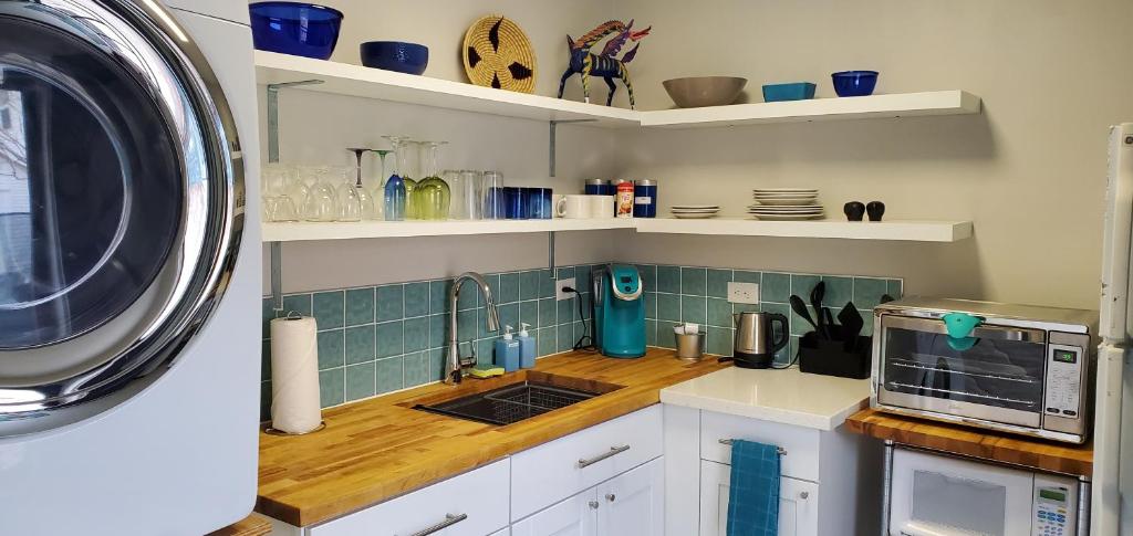 a kitchen with white cabinets and a microwave at Funky Urban Studio near UNR in Reno