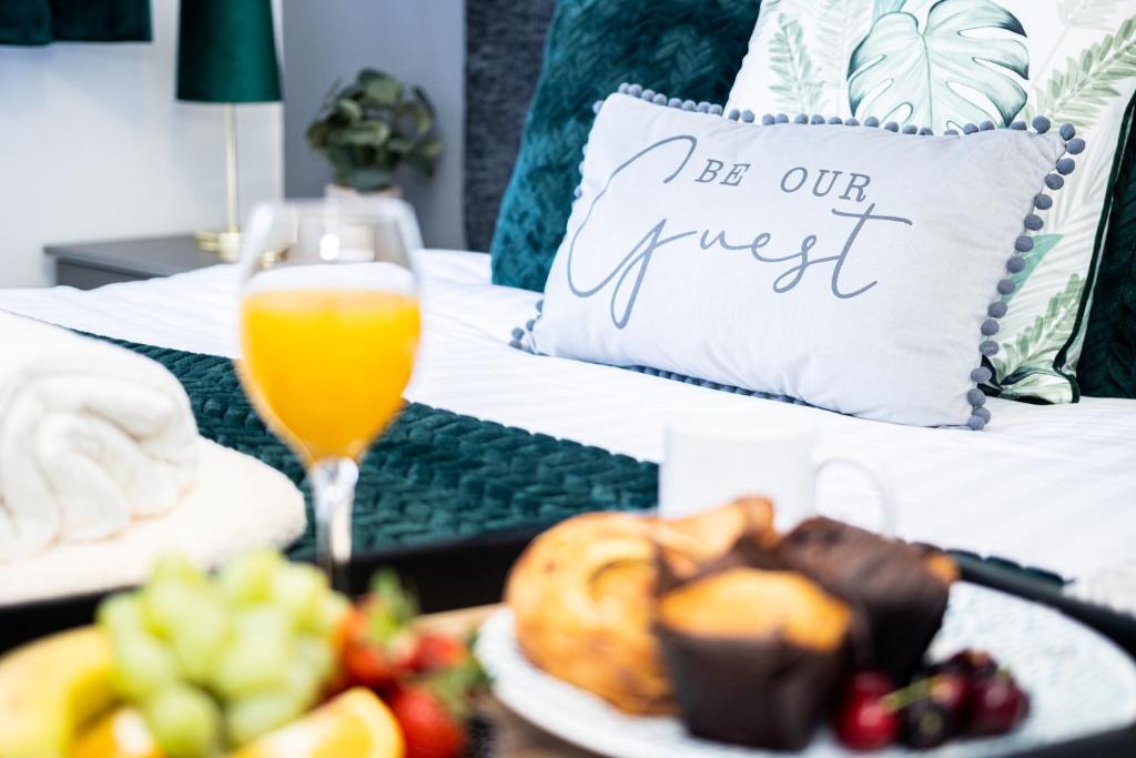 a bed with a tray of food and a glass of orange juice at TD Stourb Dudley - Luxurious 3 Bedroom House - Sleeps 7 - DY1 - Long Stay for Contractors & Families in Woodside