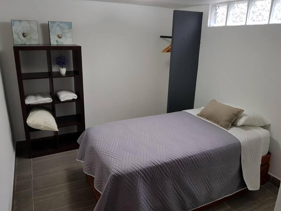 a bedroom with a bed and a shelf with towels at Great House at amazing location! 14 guests/5 rooms in Mexico City