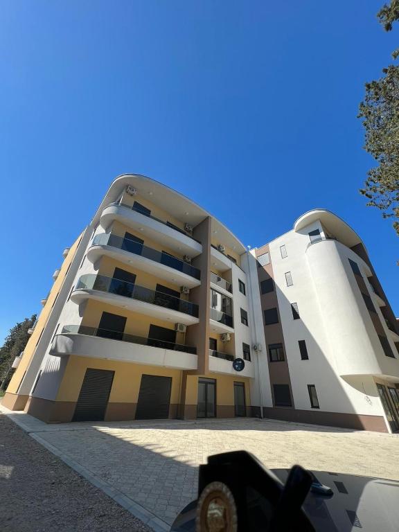 un gran edificio con un cielo azul en el fondo en Glamur Apartman - Ulcinj, en Ulcinj