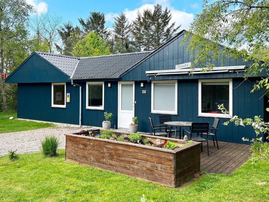 a blue house with a table in front of it at Spacious Lakeside Retreat in Ansager