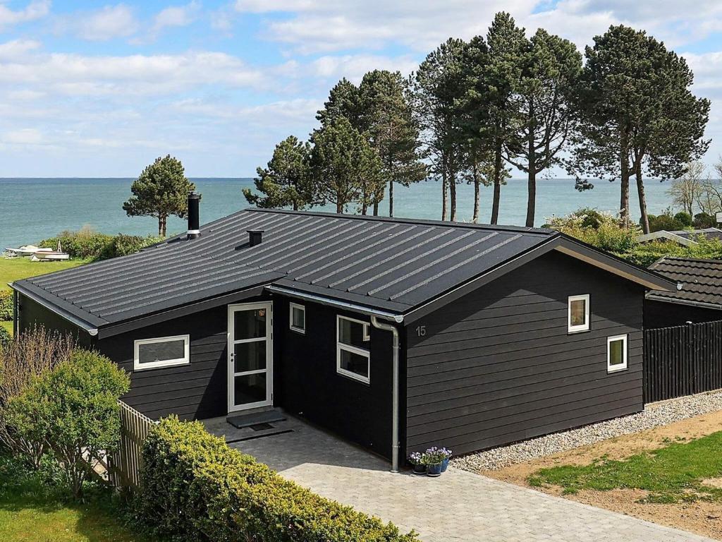 ein schwarzes Gebäude mit dem Ozean im Hintergrund in der Unterkunft 6 person holiday home in Fr rup in Frørup