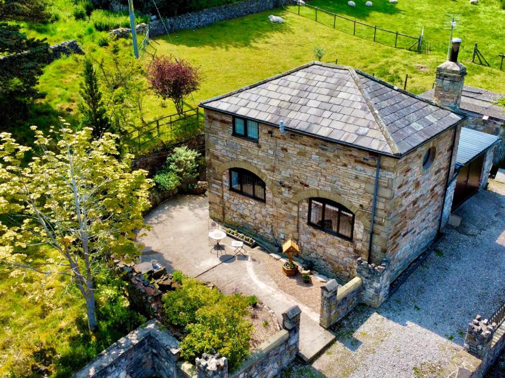 an aerial view of a stone house in a yard at The Coach House in Holywell