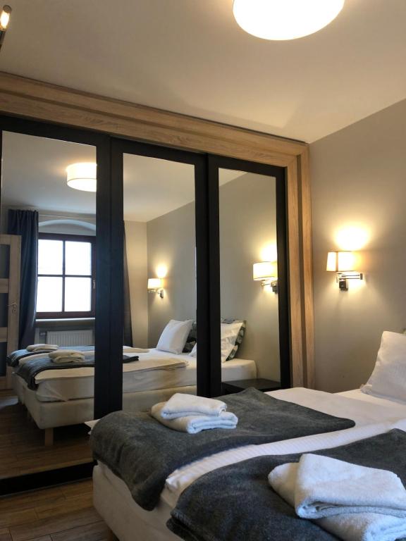 a hotel room with two beds and a mirror at Arte-locum in Wrocław