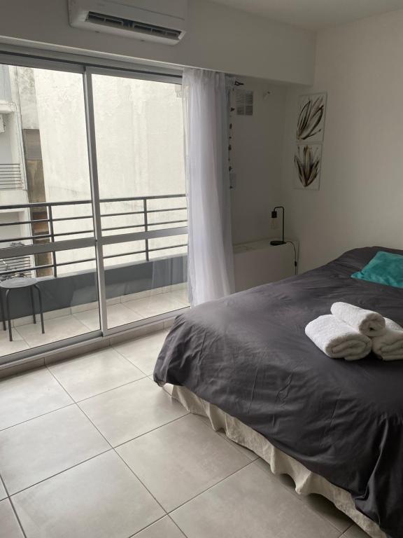 a bedroom with a bed and a large window at Hermoso Monoambiente en Rosario in Rosario