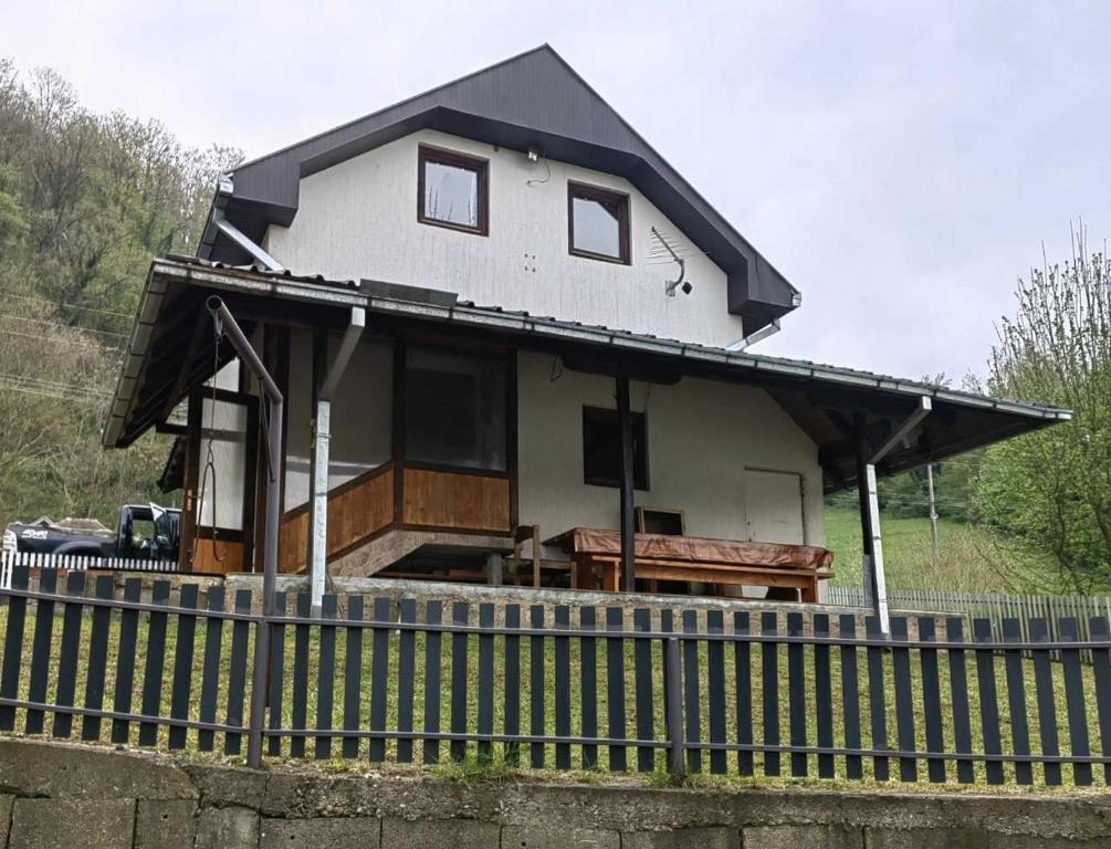 ein Haus mit einem schwarzen Dach auf einem Zaun in der Unterkunft Vikendica Drina in Ljubovija