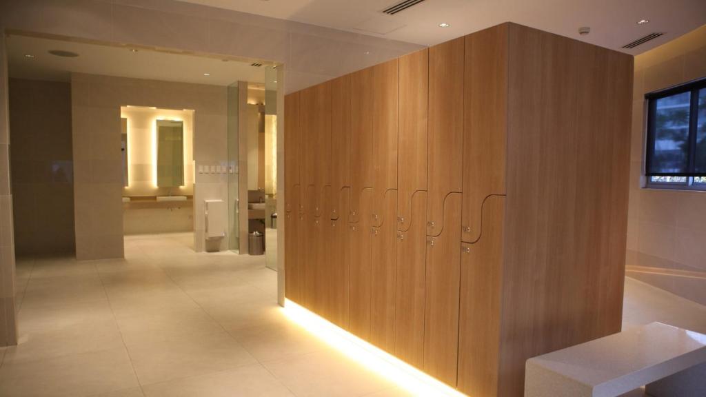 a room with a wooden wall with lockers in it at Beach Front Living in the Heart of the City, AZURE Residences in Manila