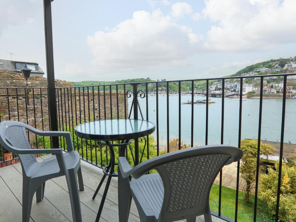 a balcony with a table and chairs and a view of the water at Ferry View in Dartmouth