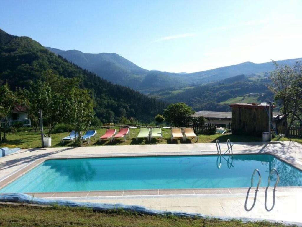 a swimming pool with mountains in the background at Gailurretan in Carranza