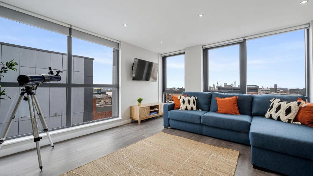 ein Wohnzimmer mit einer blauen Couch und einer Kamera in der Unterkunft Host & Stay - The Baltic Penthouse 2 in Liverpool