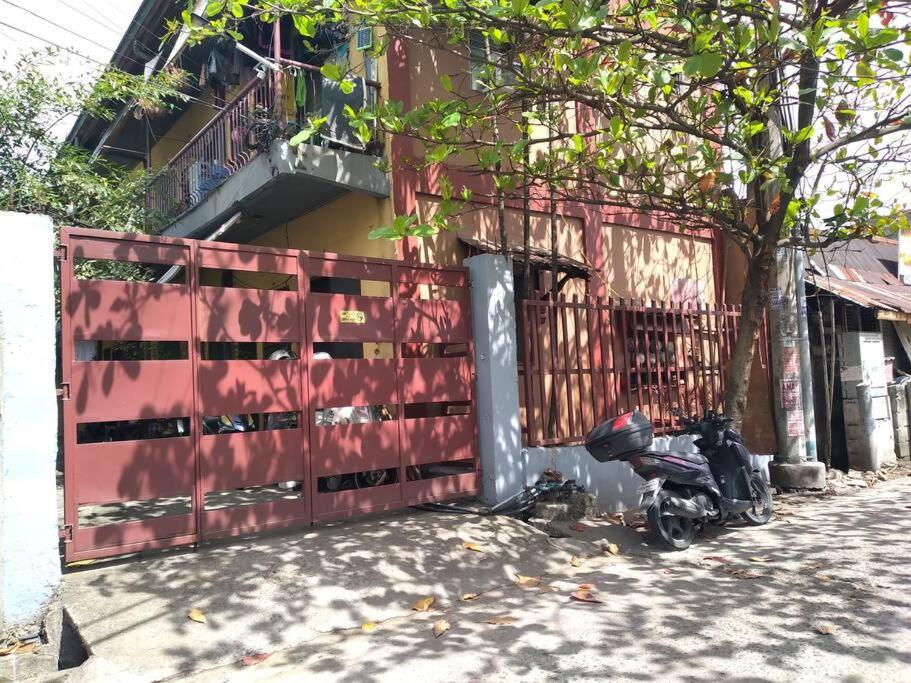 a motorcycle parked next to a red fence at TerisitaPlace - DriveBy RestStop in Taytay