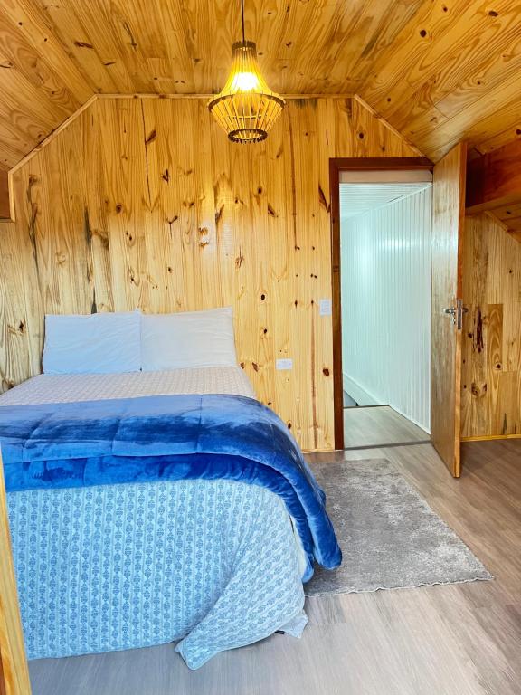 sypialnia z łóżkiem w drewnianym domku w obiekcie Chalé Modesto w mieście Campos do Jordão