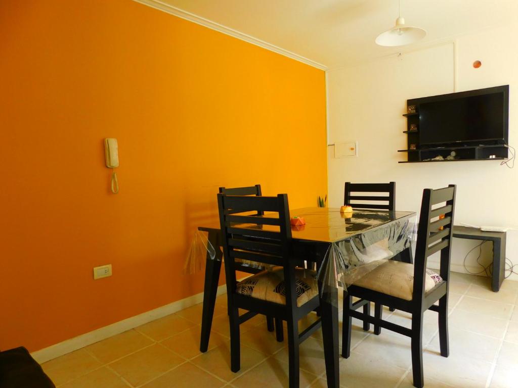 a dining room with a table and chairs and a tv at DEPARTAMENTO Nº7 COMPLEJO PRIVADO in Godoy Cruz