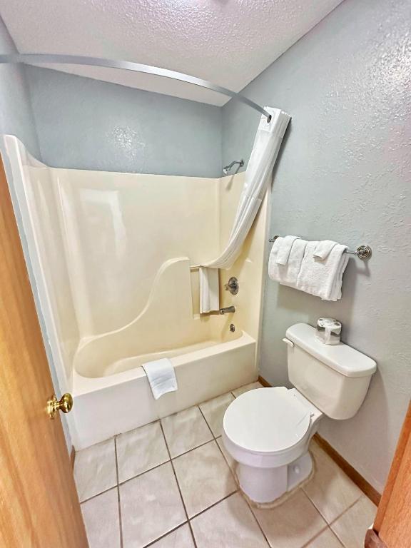 a bathroom with a toilet and a bath tub at Night Inn in Sweet Springs