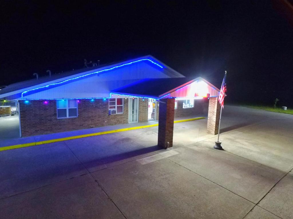 a lit up building with a blue roof at night at Night Inn in Sweet Springs