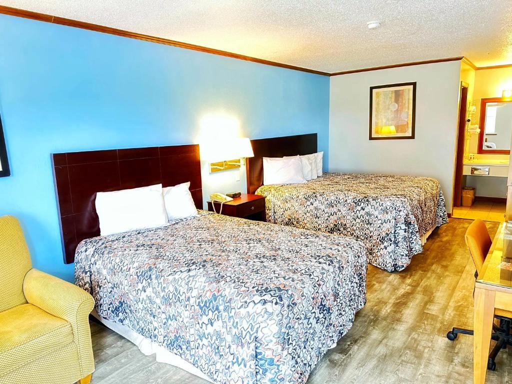 a hotel room with two beds and a chair at Night Inn in Sweet Springs
