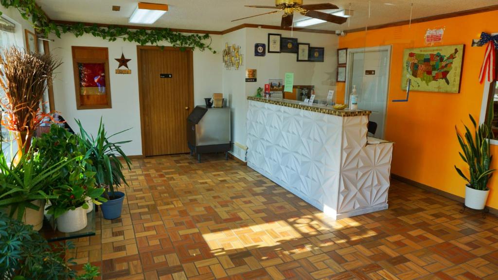 a restaurant with a counter in a room with plants at Night Inn in Sweet Springs