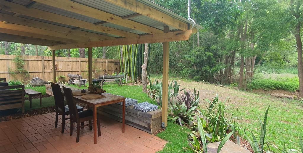 a patio with a table and chairs under a pavilion at Oasis at Burringbar waterfront holiday 